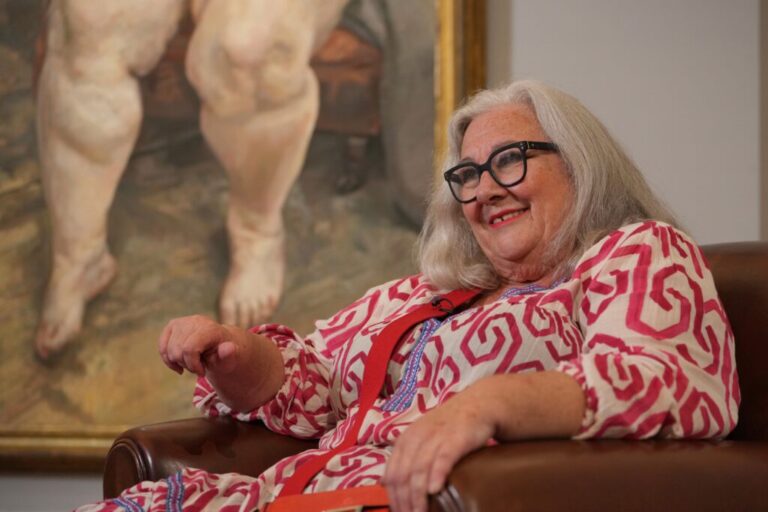 Sue Tilley, a model for British painter Lucian Freud, speaks in front of Freud's painting of her, titled