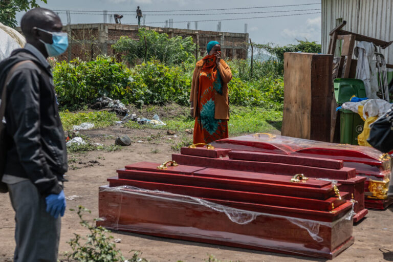 Family members of people who died of Ebola stand next to coffins at a health center in Rwampara, Congo, Wednesday, May 20, 2026. (AP Photo/Moses Sawasawa)