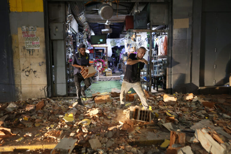 Men walk among rubble after an earthquake in Caracas, Venezuela, Wednesday, June 24, 2026. (AP Photo/Pedro Mattey)