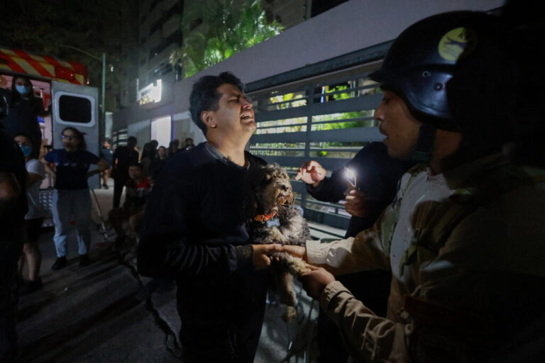 A man holding a dog cries after an earthquake in Caracas, Venezuela, Wednesday, June 24, 2026. (AP Photo/Javier Campos)