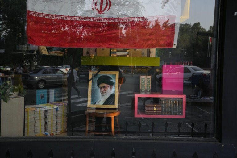 A portrait of slain Iranian Supreme Leader Ayatollah Ali Khamenei and an Iranian flag are displayed in the window of a bookstore ahead of Khamenei's funeral ceremonies, in Tehran, Iran, Thursday, July 2, 2026. (AP Photo/Vahid Salemi)