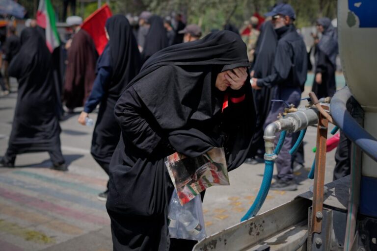 A mourner cools herself with water outside the Imam Khomeini Mosalla Grand Mosque during the funeral ceremonies for slain Iranian Supreme Leader Ayatollah Ali Khamenei and members of his family in Tehran, Iran, Saturday, July 4, 2026. (AP Photo/Altaf Qadri)