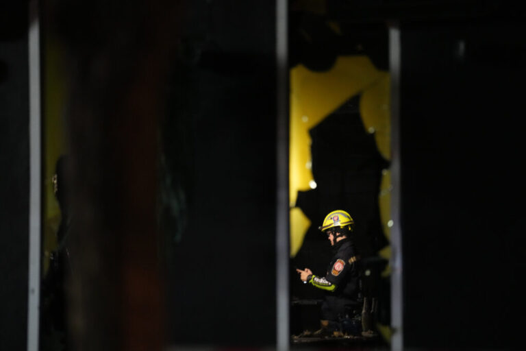 A rescuer is seen inside the site of a fire at a pub in Bangkok, Thailand, Monday, July 13, 2026. (AP Photo/Sakchai Lalit)