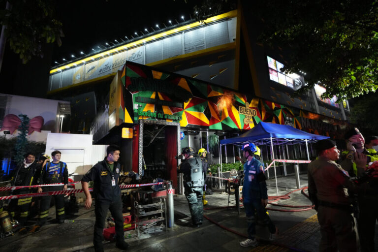 Rescuers stand near the site of a fire in Bangkok, Thailand, Monday, July 13, 2026. (AP Photo/Sakchai Lalit)