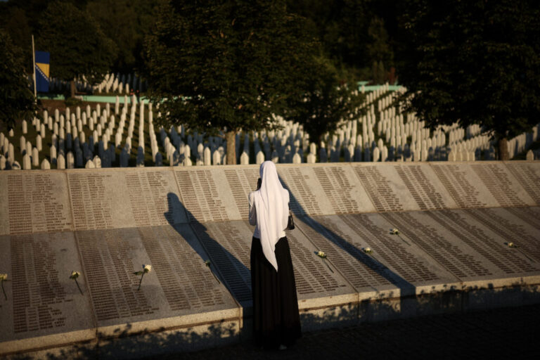 A woman stands next to the monument bearing the names of the victims of the Srebrenica genocide, at the Srebrenica Memorial Center in Potocari, Bosnia, Saturday, July 11, 2026. (AP Photo/Armin Durgut)