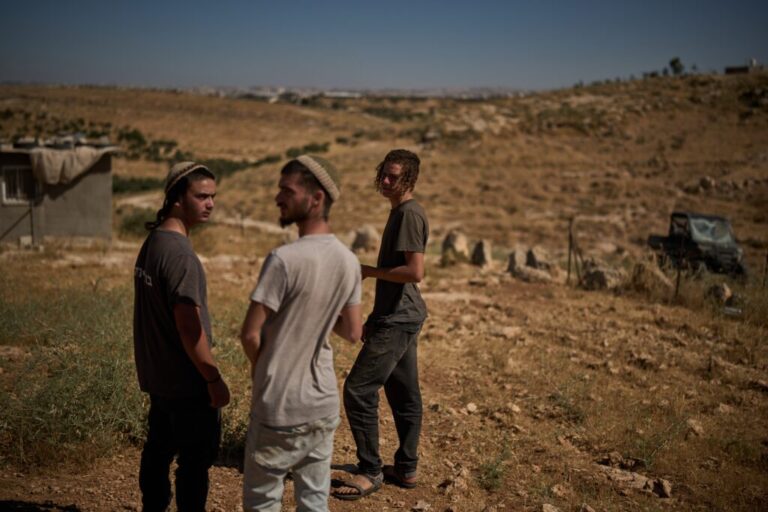 Israeli settlers stand together as they wait for the arrival of police after accusing Palestinians of setting a field on fire near the West Bank village of Susya, in the Masafer Yatta region, Thursday, June 18, 2026.(AP Photo/Leo Correa)