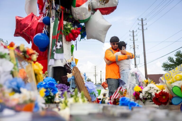 Albert Salgado is comforted by his girlfriend at the site where his uncle Lorenzo Salgado Araujo was shot by an ICE officer in Houston on Friday, July 10, 2026. (AP Photo/Annie Mulligan)