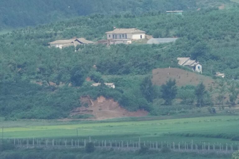 A North Korean flag, center top, flutters in the wind on North Korea's town, Kaepoong, as seen from the unification observatory in Paju, South Korea, Tuesday, July 7, 2026. (AP Photo/Lee Jin-man)