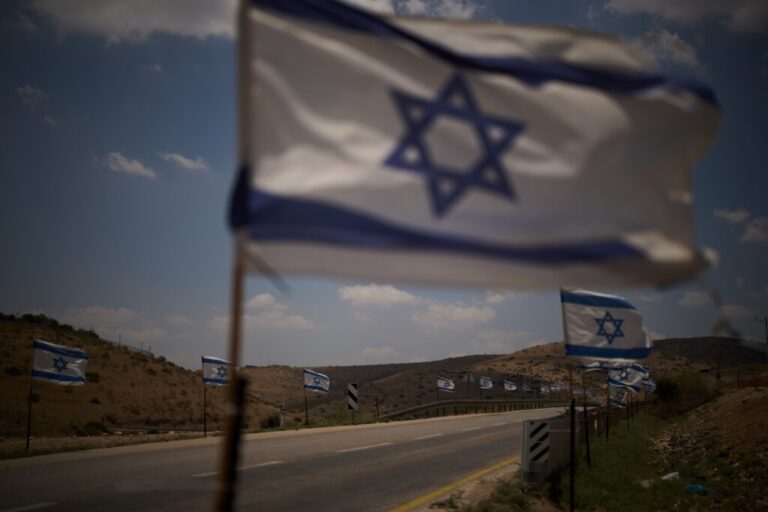 Israeli flags are seen lining a road in the northern Jordan Valley in the occupied West Bank, Wednesday, June 24, 2026. (AP Photo/Leo Correa)
