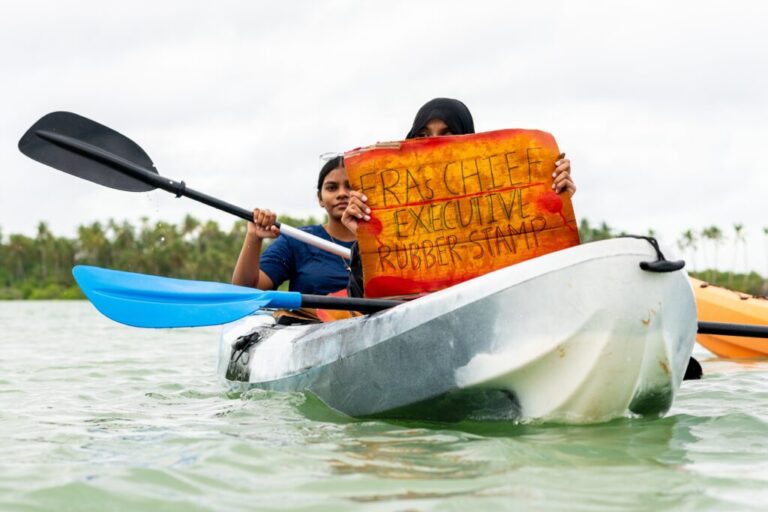 A participant holds a sign as part of Project ThimaaVeshi, a youth-led demonstration against ongoing reclamation project damaging mangroves off the coast of Addu City, Maldives, June 3, 2026. (AP Photo/Sophia Nasif)
