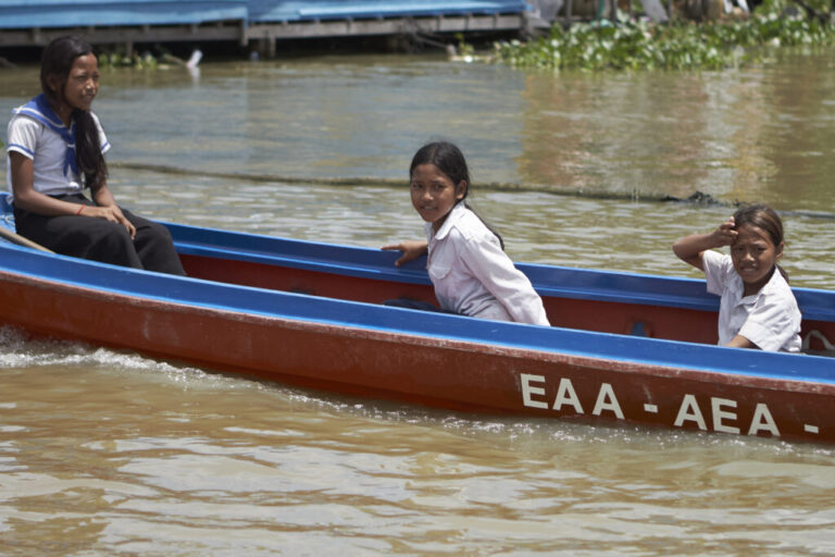Sou Sreynich, 13, rides a boat to return home from school on one of the floating villages of Cambodia's Tonle Sap Lake on Monday, June 29, 2026. (AP Photo/Aniruddha Ghosal)