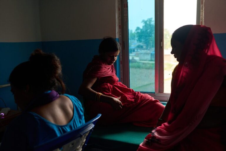 Nitu Devi, 22, who is pregnant, sits on a bed before an ultrasound inside a clinic in Gaur, Nepal, on May 20, 2026. (AP Photo/Bram Janssen)