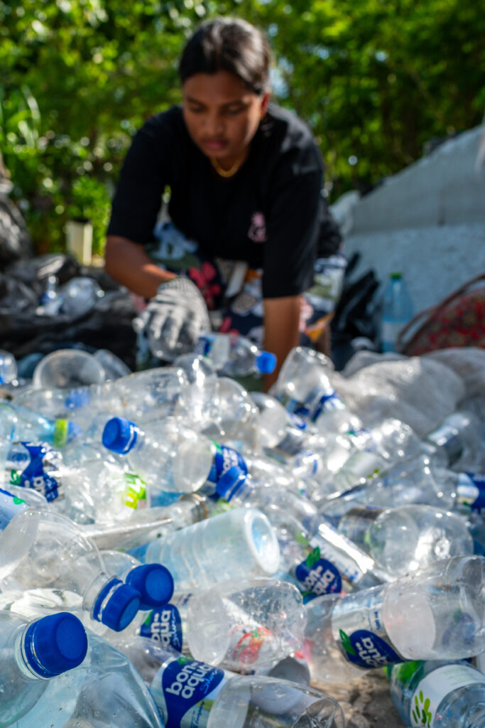 Yania Hussain Ishan, co-founder of youth group Barnacles, sorts through the first batch of plastic waste collected in the joint plastic pollution clean in Male, Maldives, June 19, 2026. (AP Photo/Sophia Nasif)