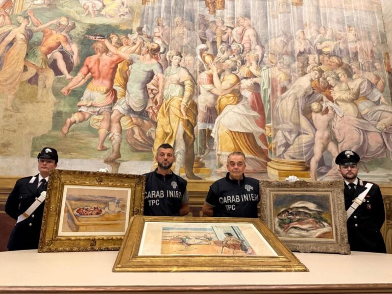 In this picture made available by the Italian Carabinieri in Parma, northern Italy, Friday, Aug. 14, 2026, Carabinieri pose near three artworks recovered following a police operation: