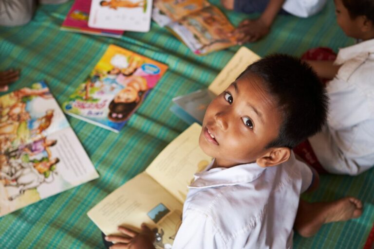 A student looks up from his picture book at a school in one of the floating villages of Cambodia's Tonle Sap Lake on Monday, June 29, 2026. (AP Photo/Aniruddha Ghosal)